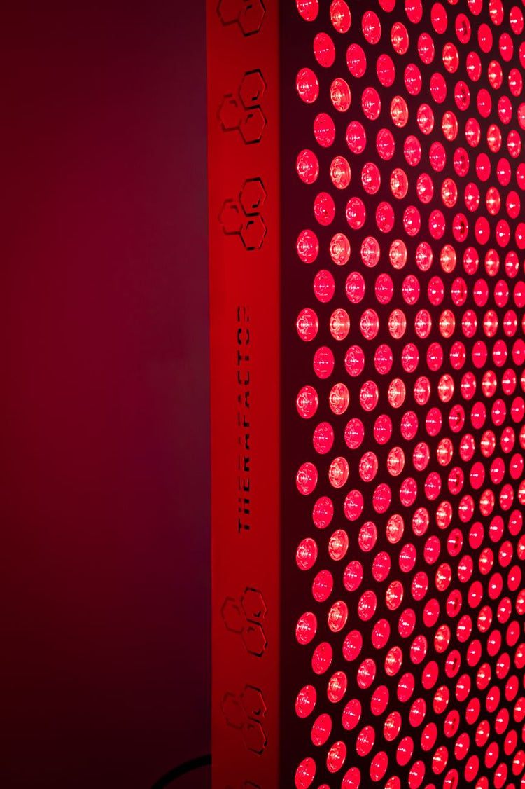 Lateral do painel TheraPRO com a marca TheraFactor e LEDs de luz vermelha acesos