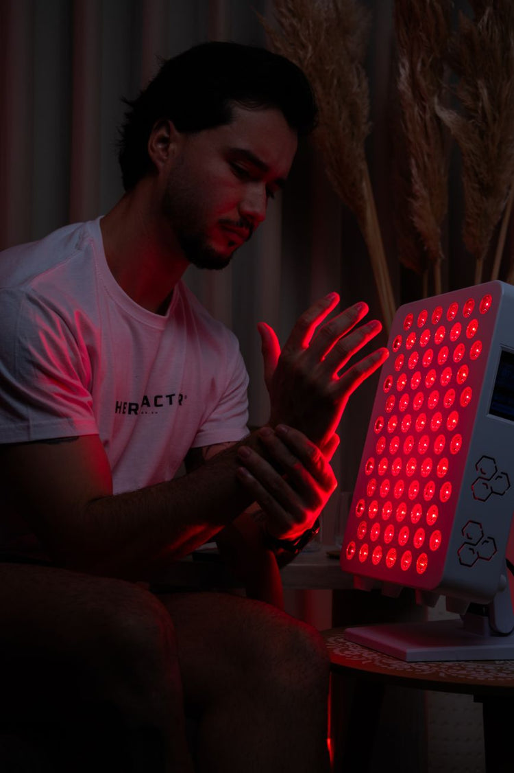 Homem a fazer terapia de luz vermelha nas mãos com o painel TheraPRO 120